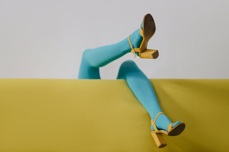 Stylized image featuring vibrant blue tights and yellow heels on a minimalist sofa.