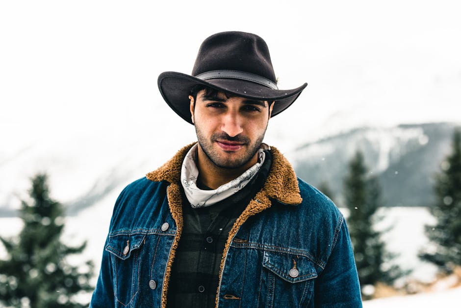 A rugged man in a cowboy hat poses in a snowy landscape at Jasper National Park.