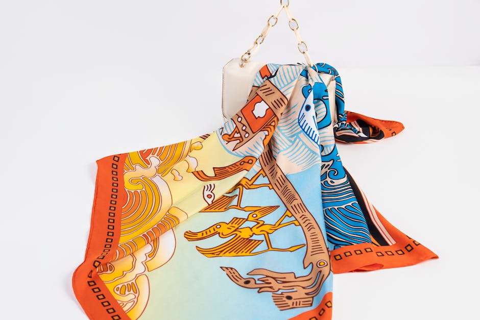 Vibrant silk scarf draped over a handbag, featuring a bold artistic pattern.