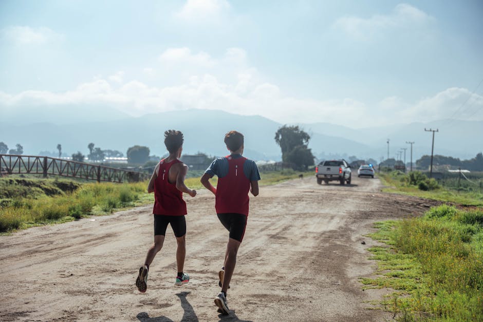Two men jogging on a dirt road, embracing fitness in a rural setting.